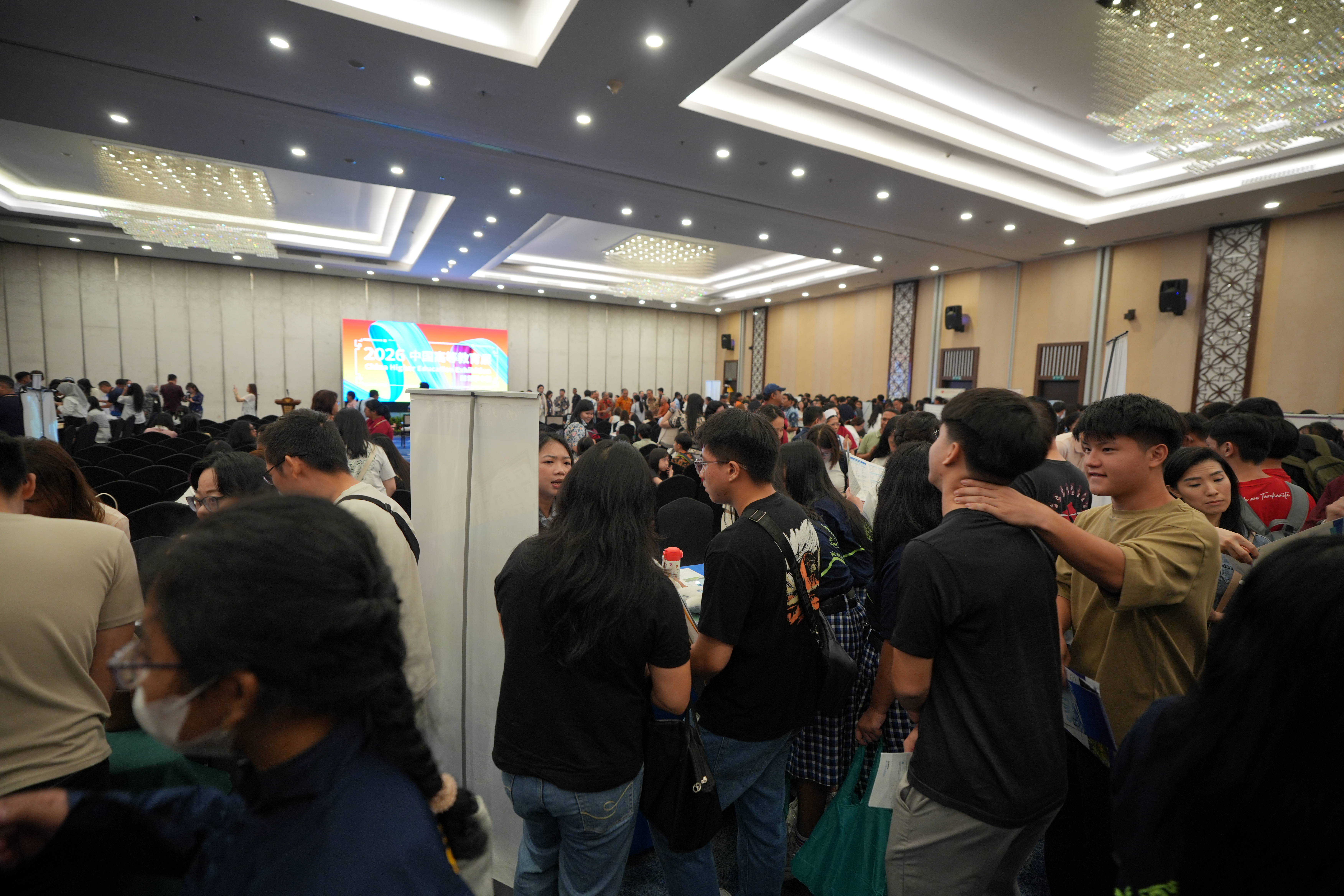 Students exploring university booths at the exhibition